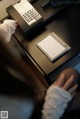 A person sitting at a desk with a phone and a notepad.