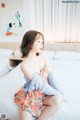 A woman sitting on a bed in a bedroom.