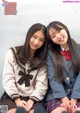 A couple of young women sitting next to each other.